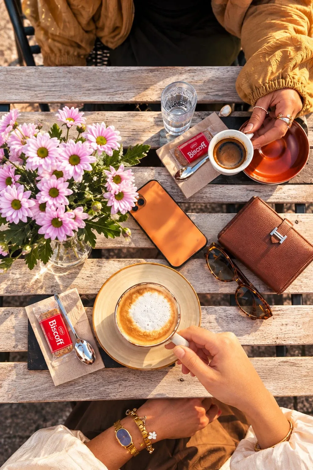Cappuccino und Espresso auf einem Gartentisch mit Blumen
